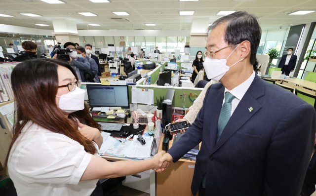 한덕수 국무총리가 31일 세종시 새롬동 주민센터에 마련된 제8회 전국동시지방선거 투표소를 방문해 담당 직원을 격려하고 있다./연합뉴스