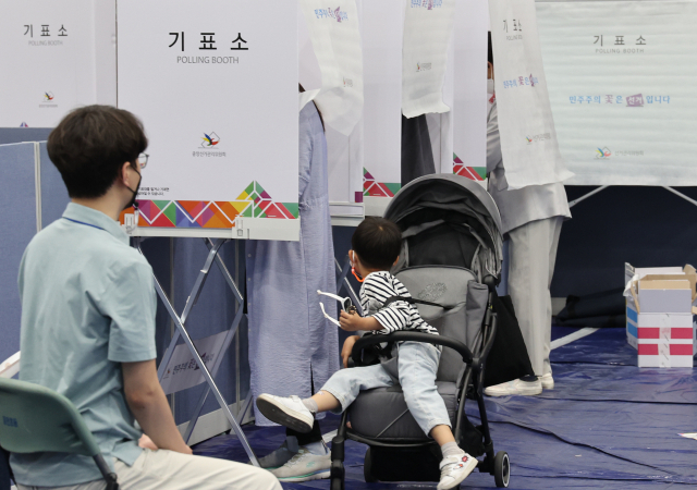 제8회 전국동시지방선거일인 1일 송파구 잠전초등학교 투표소에서 한 어린이가 엄마를 찾고 있다. 연합뉴스