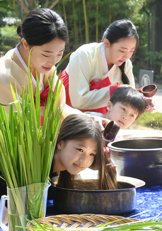 단오를 하루 앞둔 2일 오전 서울 종로구 국립민속박물관 오촌댁 앞마당에서 열린 '단오 세시체험' 행사에서 어린이들이 창포물에 머리감기 체험을 하고 있다. 단오에는 창포 삶은 물로 머리를 감는 풍속이 있다. 창포 특유의 향기가 나쁜 귀신을 쫓으며, 창포물로 머리를 감으면 머리에 윤기가 난다는 이유에서다./권욱 기자 2022.06.02