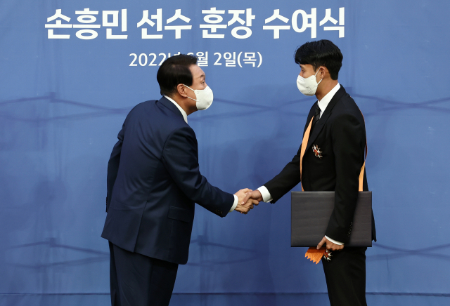 윤석열 대통령이 2일 오후 서울월드컵경기장에서 아시아 선수 최초로 잉글랜드 프로축구 프리미어리그 득점왕에 오른 손흥민에게 체육훈장 가운데 최고 등급인 청룡장을 수여하고 있다. 연합뉴스