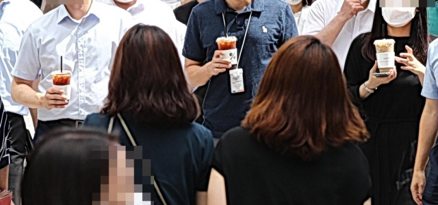 시민들이 커피를 마시며 길을 걷고 있다. 연합뉴스