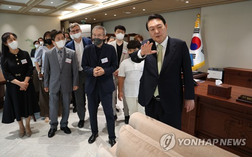 윤석열 대통령이 지난달 25일 오전 서울 용산 대통령실 청사에서 열린 국민희망대표 초청 대통령 취임 기념 시계 증정식을 마친 뒤 오찬에 앞서 배우 오영수 씨를 비롯한 참석자들에게 집무실을 둘러보며 설명해주고 있다. 연합뉴스