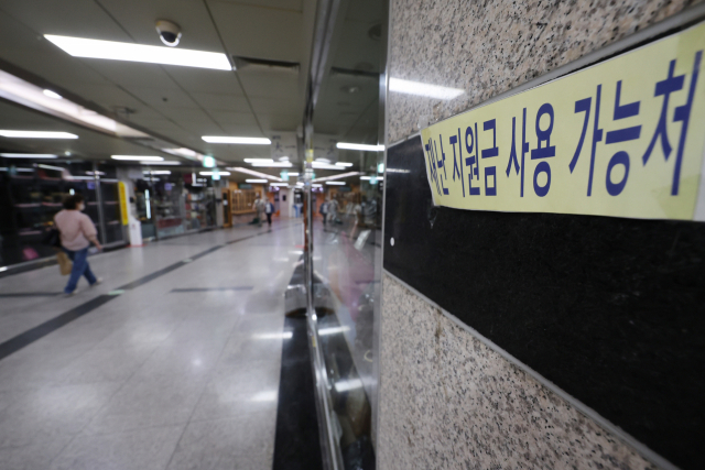 29일 오후 서울 명동 인근 지하상가의 한 매장에 재난지원금 사용가능 문구가 붙어 있다. 연합뉴스