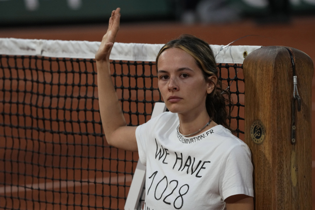 3일 열린 프랑스오픈 테니스 준결승에서 한 환경운동가가 난입해 그물에서 항의하고 있다. AP 연합뉴스