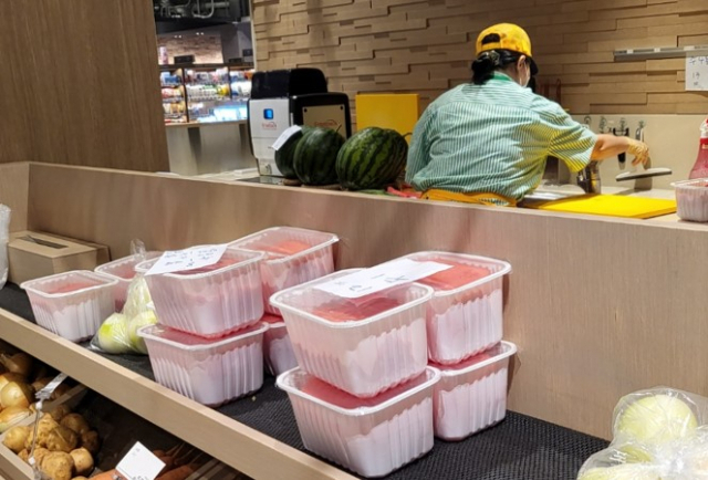 더현대 서울 지하 1층 식품관의 ‘프레쉬 테이블’에서 직원이 과일을 손질하고 있다./송주희기자