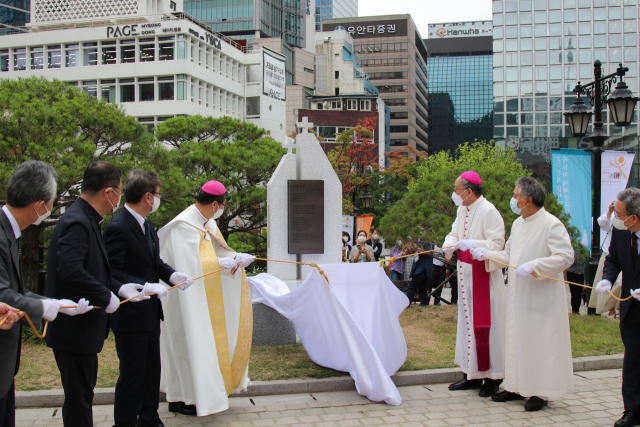 5일 서울 명동대성당에서 열린 ‘김수환 추기경 탄생 100주년 기념 시비’ 제막식에서 천주교 서울대교구장인 정순택(왼쪽 네 번째) 대주교가 교구 사제 등 관계자들과 함께 시비 가림천을 걷어내고 있다. 사진 제공=천주교 서울대교구