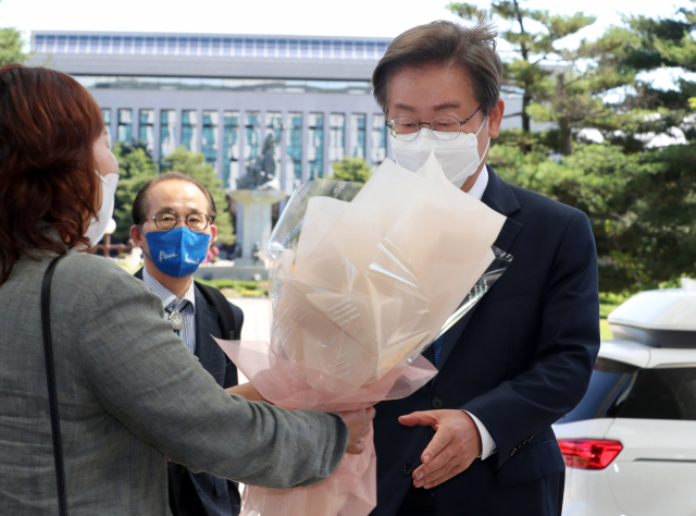 이재명 더불어민주당 의원이 7일 오전 서울 여의도 국회의원회관에 첫 출근을 하며 지지자로부터 꽃다발을 받고 있다. 성형주 기자