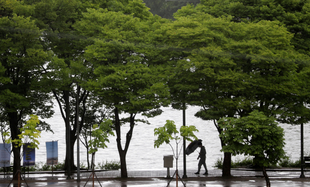 우산을 쓴 시민이 6일 오전 강원 춘천시 공지천 산책로에서 아침 산책을 하고 있다. 연합뉴스