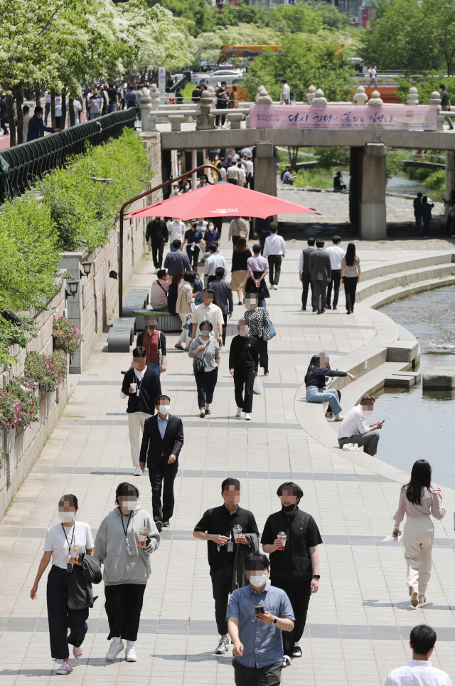 서울 청계천에서 인근 직장인들이 점심 식사를 마친 뒤 산책을 즐기고 있다. 연합뉴스