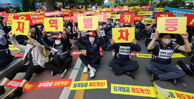 8일 서울 국회의사당역 인근에서 열린 최저임금 제도개선 촉구 소상공인 결의대회에서 참가자들이 손팻말을 흔들고 있다./연합뉴스