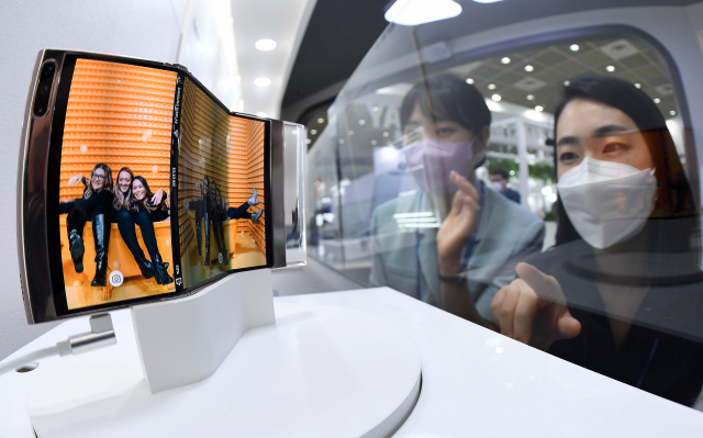 삼성디스플레이가 개발한 두 번 접히는 디스플레이 장치를 기술 박람회 관람객들이 살펴보고 있다. 연합뉴스