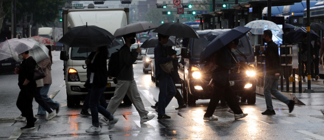 우산을 쓴 시민들이 지난달 18일 서울 시내 길거리의 횡단보도를 걷고 있다. 연합뉴스