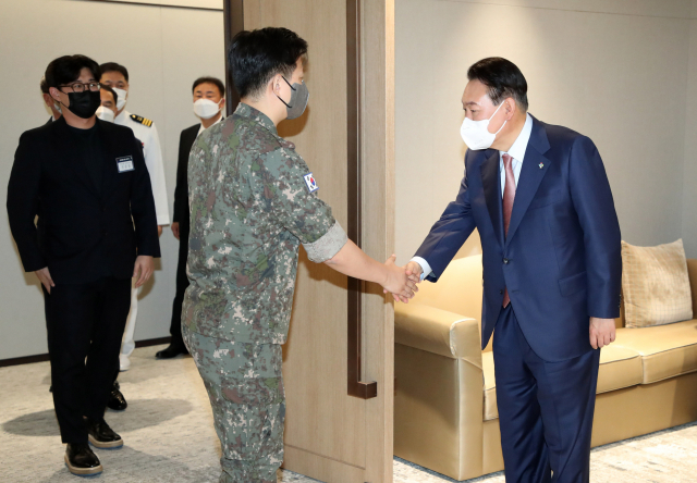 윤석열 대통령이 9일 오전 용산 대통령실 청사에서 열린 ‘호국영웅 초청 소통식탁’ 행사에 앞서 2015년 북한의 도발로 부상한 목함지뢰 영웅 김정원 중사와 인사하고 있다. 연합뉴스