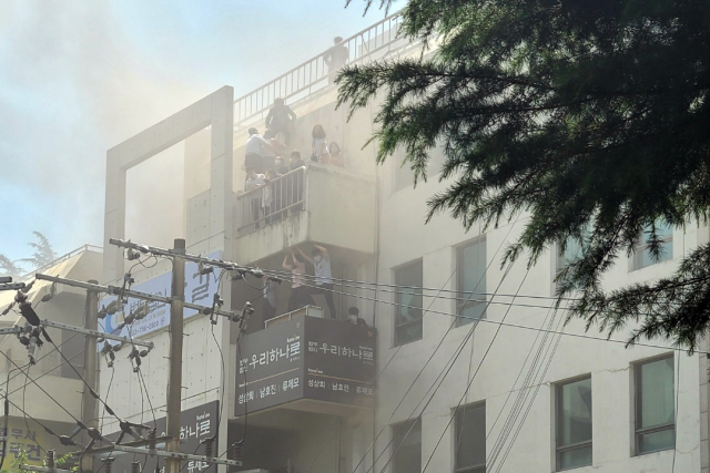 9일 대구 수성구 범어동 대구지방법원 인근 변호사 사무실 빌딩에서 불이나 시민들이 옥상 부근에서 구조를 기다리고 있다. 연합뉴스