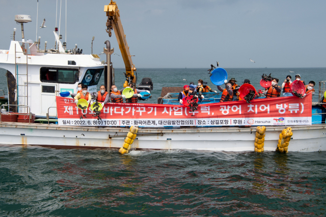 한화토탈에너지스 임직원과 어민들이 삼길포해안에서 치어를 방유하고 있다. 사진제공=한화토탈에너지스