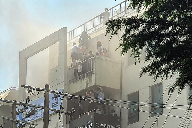 대구 수성구 범어동의 변호사 사무실 빌딩에서 9일 화재가 발생해 7명이 숨지고 40여 명이 중경상을 입은 가운데 건물 위층 발코니로 대피한 시민들이 구조를 기다리고 있다. 대구=연합뉴스