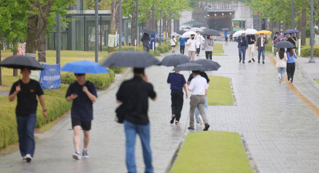 서울에 비가 내린 9일 오후 서울 서대문구 연세대학교에서 학생과 시민들이 우산을 쓰고 이동하고 있다. 연합뉴스