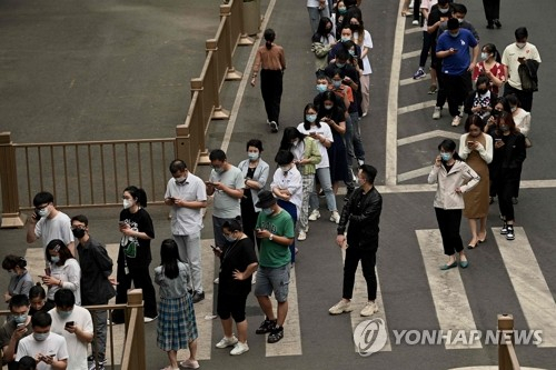 9일 중국 수도 베이징의 한 코로나19 검사소 앞에 시민들이 줄지어 서 있다./연합뉴스