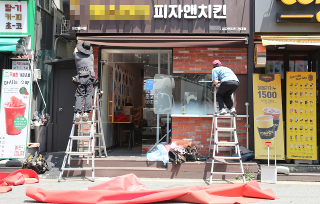 지난 12일 서울 광진구 건대입구역 부근 한 음식점에서 관계자들이 개업 준비를 돕고 있다. 당정은 지난 11일 코로나 영업제한으로 피해를 본 소상공인·자영업자 370만명을 대상으로 1인당 최소 600만원씩 지급하기로 했다.연합뉴스