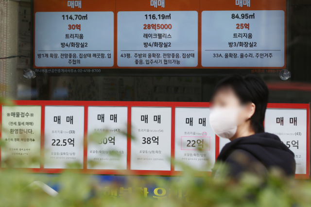 한 여성이 서울의 공인중개사무소 앞을 지나가고 있다./연합뉴스