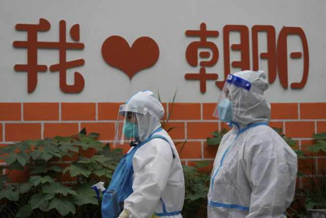 클럽발 확진자가 이틀째 60명 넘게 나온 베이징시에서 12일 차오양구 일대를 방호복을 입은 의료진이 지나가고 있다. AP연합