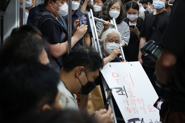 박경석 전국장애인차별철폐연대(전장연) 상임공동대표와 활동가들이 13일 오전 서울 혜화역에서 지하철 집회를 재개하며 장애인권리예산과 이동권 보장을 촉구하고 있다. 연합뉴스