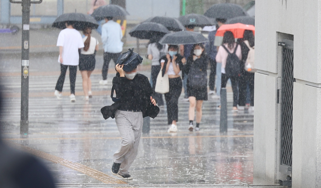 한 시민이 9일 오후 서울 서대문구 연세대학교에서 한 시민이 가방으로 비를 막으며 뛰어가고 있다. 연합뉴스