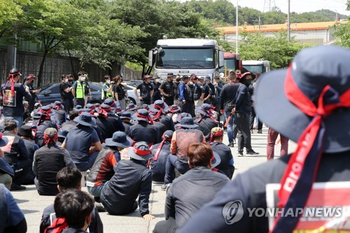 지난 10일 경북 포항시 남구 포항철강산업단지 내 한 철강업체 입구에서 화물연대 포항지역본부 조합원 200여명이 회사에 들어가려는 트레일러를 막아서고 있다. 경찰이 출동한 가운데 화물연대는 30여 분간 승강이를 벌이다가 통행로를 열었다. 연합뉴스