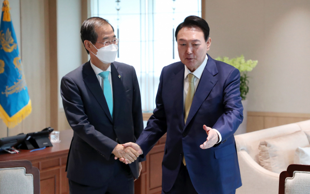 윤석열 대통령과 한덕수 국무총리가 13일 서울 용산 대통령실 청사 집무실에서 열린 주례 회동 사전 환담에 참석해 악수하고 있다. 연합뉴스