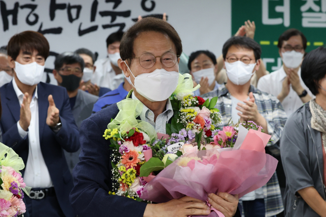 전국동시지방선거 서울교육감 선거에서 3선에 도전한 조희연 후보가 2일 새벽 서울 서대문구 후보자 사무실에서 개표방송을 지켜보던 중 당선이 확실시되자 지지자들의 축하를 받으며 기뻐하고 있다. 연합뉴스