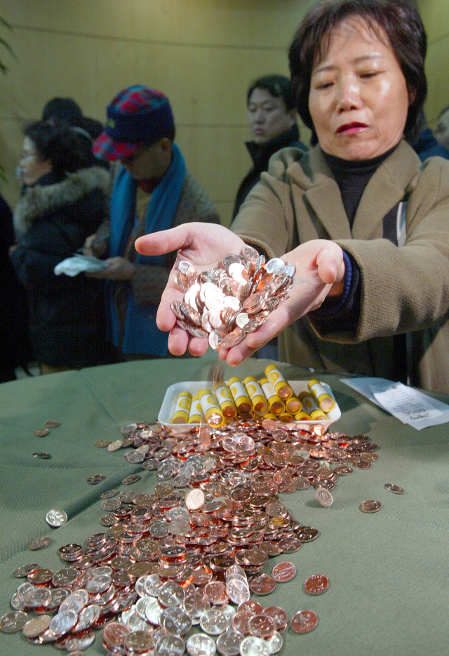 새 10원 동전이 유통되기 시작한 2006년 12월 18일 한국은행 화폐교환창구에서 한 시민 새 동전을 살펴보고 있다. 이호재 기자.