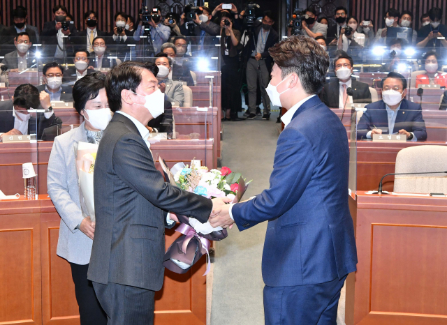 이준석 국민의힘 대표가 14일 서울 여의도 국회에서 열린 국민의힘 의원총회에서 안철수 의원에게 꽃다발을 전달하고 있다. 성형주 기자