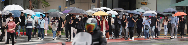 15일 오전 우산을 쓴 시민들이 서울 중구 숭례문 앞 횡단보도를 지나고 있다. 연합뉴스