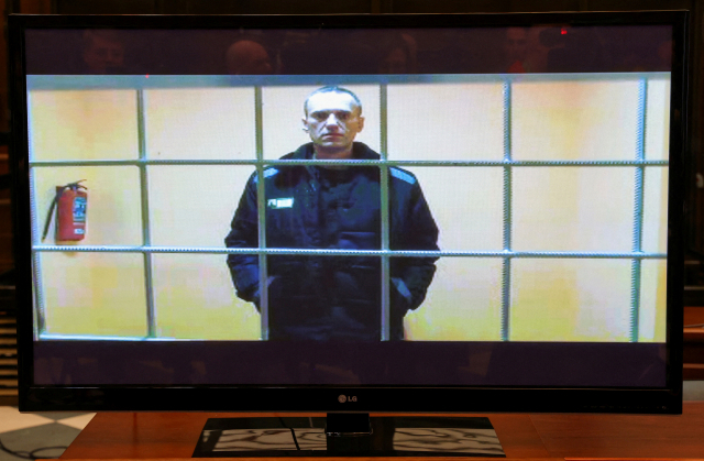 블라디미르 푸틴 러시아 대통령의 정적인 야권 지도자 알렉세이 나발니의 모습이 지난달 24일(현지시간) 모스크바 법원 법정에 설치된 화면에 비치고 있다. 로이터연합뉴스
