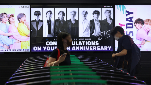그룹 방탄소년단(BTS)이 팀 활동 잠정 중단 선언한 15일 오후 서울 지하철 2호선 강남역에 데뷔 9주년 축하 영상이 상영되고 있다. 연합뉴스