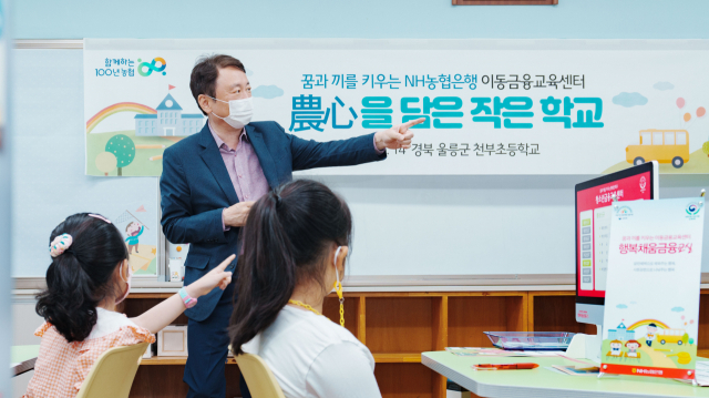 지난 14일 울릉군 북면 천부초등학교를 방문한 권준학 NH농협은행장이 '행복채움금융교실' 은행원 체험을 함께하고 있다.