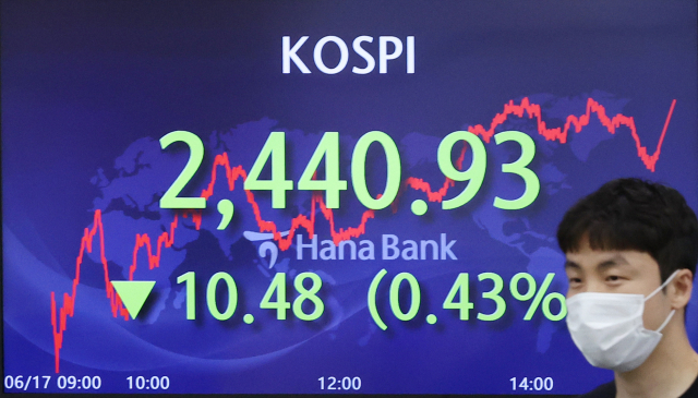 경기 침체 우려가 확산하면서 코스피가 장 한때 2,400선 밑까지 내려갔던 17일 오후 서울 중구 하나은행 본점 딜링룸에서 직원이 전광판 앞을 지나고 있다./연합뉴스