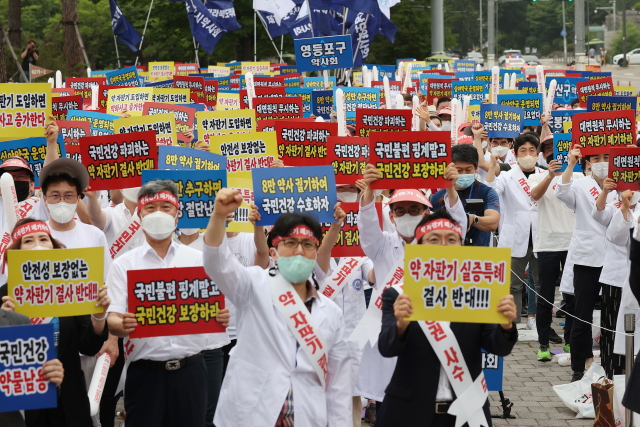 대한약사회 회원들이 19일 오후 서울 용산구 대통령 집무실 앞에서 열린 약 자판기 저지 약사 궐기대회에서 구호를 외치고 있다. 연합뉴스