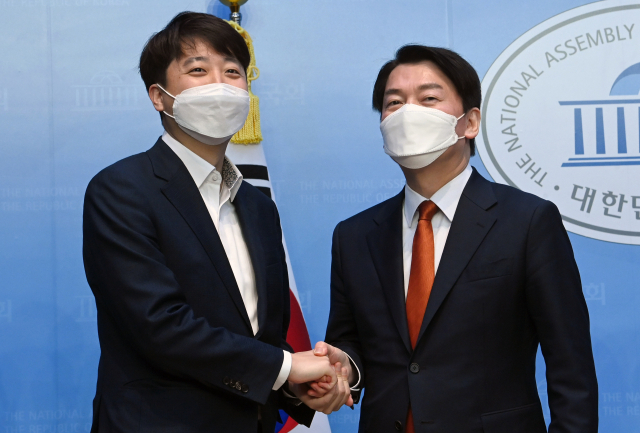 이준석 국민의힘 대표(왼쪽)와 당시 안철수 국민의당 대표가 지난 4월 18일 서울 여의도 국회 소통관에서 기자회견을 열고 합당을 선언한 뒤 악수하고 있다. 성형주 기자