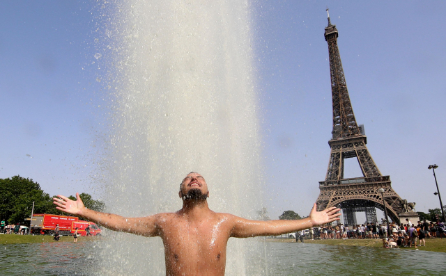 18일(현지시간) 프랑스에서 한 남성이 파리 에펠탑 인근 트로카데로 분수에 뛰어들어 더위를 식히고 있다.