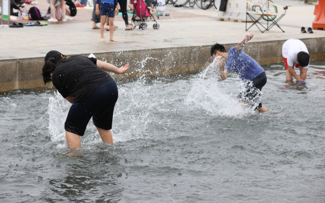 서울 한낮기온이 29도까지 오른 19일 오후 영등포구 여의도 한강시민공원 물빛광장에서 어린이들이 물장난을 치며 놀고 있다. 연합뉴스