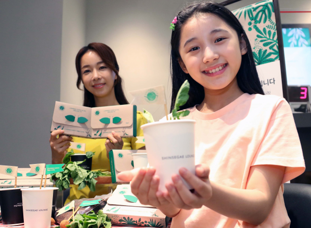 신세계백화점 모델들이 환경의 달을 맞아 고객들에게 제공한 친환경 식물 재배 키트를 소개하고 있다./사진 제공=신세계백화점