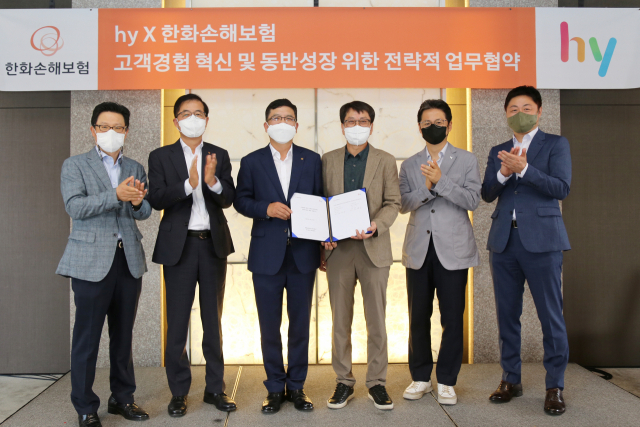 강성수(왼쪽에서 세번째) 한화손해보험 대표이사와 김병진(〃네번째) hy 대표이사가 21일 서울 중구 더플라자 호텔에서 MOU 체결 후 임직원들과 기념 촬영을 하고 있다. 사진 제공=한화손해보험