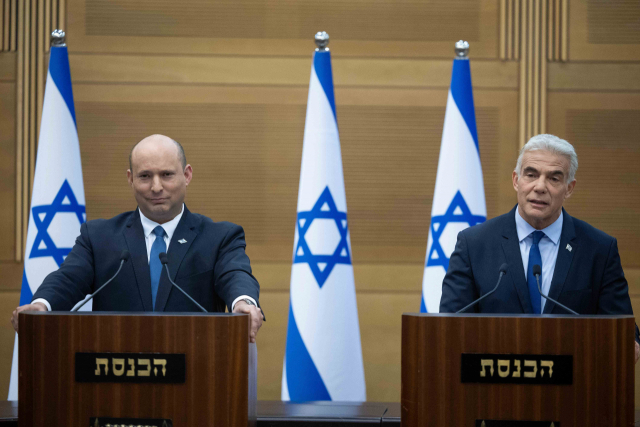 나프탈리 베네트(왼쪽) 이스라엘 총리와 야이르 라피드 외무장관이 20일(현지 시간) 예루살렘에서 연립정부 자진 해산을 발표하고 있다. 신화연합뉴스