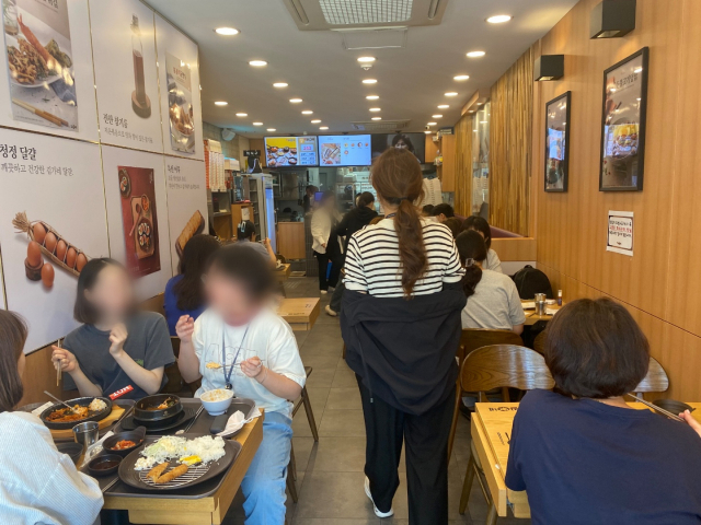 서울 중구의 한 분식집이 21일 점심 식사를 하기 위해 모인 시민들로 북적거리고 있다. 이건율 기자