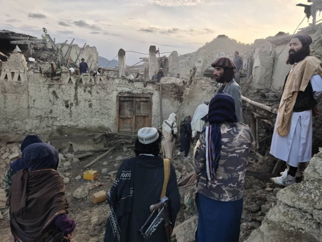 22일(현지 시간) 아프가니스탄 남동부의 파크티카주에서 현지 주민들이 지진으로 붕괴한 주택 잔해를 바라보고 있다.