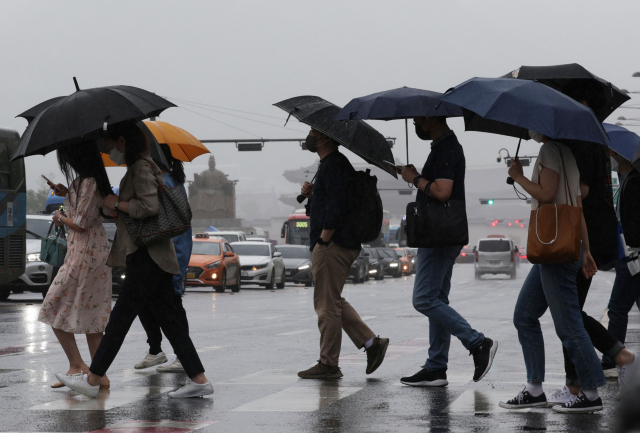 서울 광화문역 인근에서 시민들이 우산을 쓰고 길을 걷고 있다. 연합뉴스