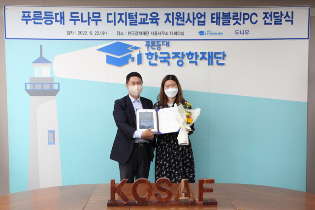 이석우(왼쪽) 두나무 대표가 지난 22일 한국장학재단 서울사무소에서 진행된 '푸른등대 두나무 디지털교육 지원사업 태블릿PC 전달식'에서 한 대학생에게 장학증서와 디지털기기를 전달하고 있다. 사진 제공=두나무