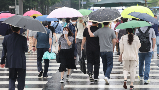 전국 곳곳에 장맛비가 내리기 시작한 23일 오전 서울 광화문광장에서 시민들이 우산을 쓴 채 걸어가고 있다. 연합뉴스