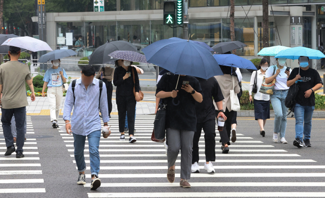 전국적인 장마 시작이 예보된 23일 오전 시민들이 서울 중구 을지로입구역 인근에서 우산을 쓰고 횡단보도를 건너고 있다. 연합뉴스
